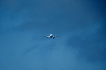 Airplane in the cloudy sky. An airplane flying near an airfield with its landing gear down