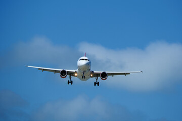 Airplane in the cloudy sky. An airplane flying near an airfield with its landing gear down