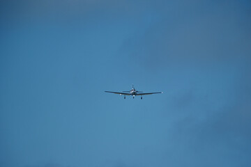 Airplane in the cloudy sky. An airplane flying near an airfield with its landing gear down