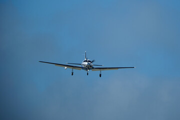 Small propeller airplane flying in the blue sky on a sunny day. Single Engine Turboprop Aircraft Landing