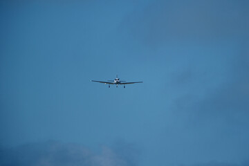 Airplane in the cloudy sky. An airplane flying near an airfield with its landing gear down