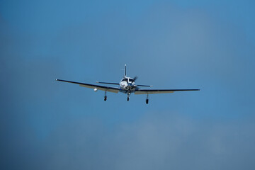 Small propeller airplane flying in the blue sky on a sunny day. Single Engine Turboprop Aircraft Landing