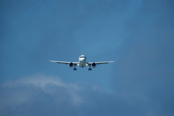 Airplane in the cloudy sky. An airplane flying near an airfield with its landing gear down