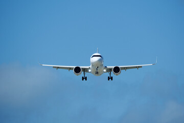Airplane in the cloudy sky. An airplane flying near an airfield with its landing gear down