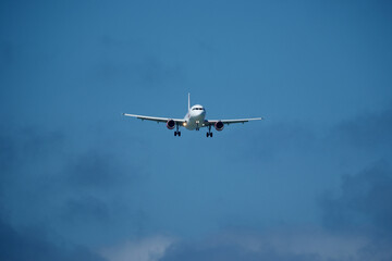 Airplane in the cloudy sky. An airplane flying near an airfield with its landing gear down