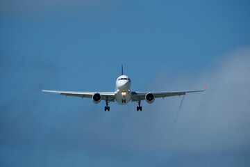 Airplane in the cloudy sky. An airplane flying near an airfield with its landing gear down