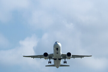Airplane in the cloudy sky. An airplane flying near an airfield with its landing gear down