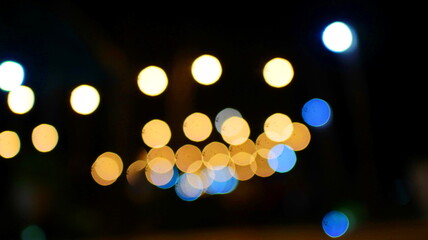 Blurred city lights glow warmly against the dark night sky, creating a festive and magical...