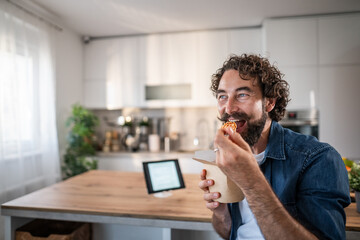 Man enjoying takeout meal at home kitchen