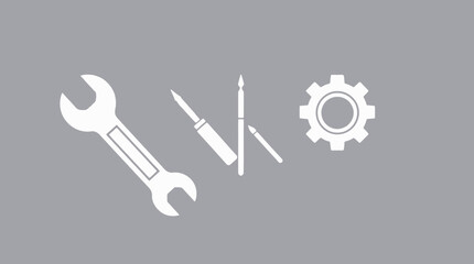 Illustration of a wrench, screwdriver, pencil, and gear, all in white against a gray background.