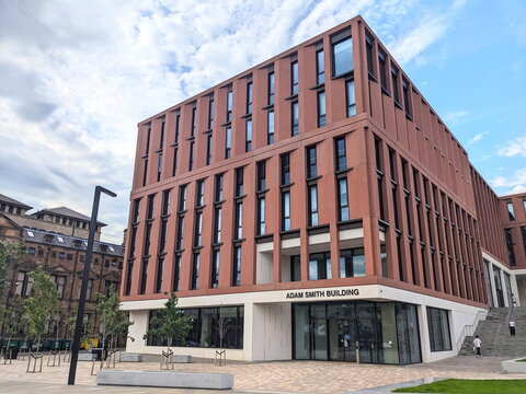 Contemporary architecture of the Adam Smith Building at University of Glasgow under a cloudy sky