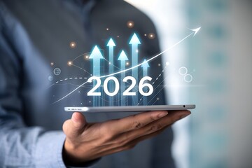 Businessman holding graph and upward arrow from 2025 to 2026, representing data-driven business growth, strategic planning, performance forecast, annual success and financial improvement.