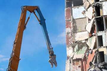 Demolition of multi-story building with heavy machinery equipment.