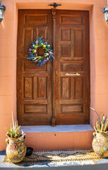 Beautiful old wooden door of Lindos and two ceramic flower pots, , Rhodes, Greece