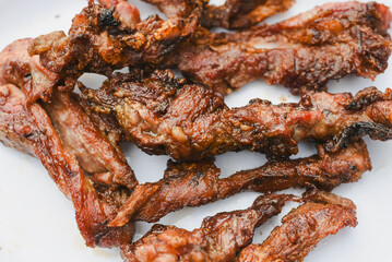 close-up overhead shot of several pieces of cooked, grilled, or fried meat served on a plate