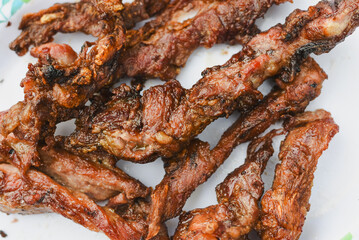 close-up overhead shot of several pieces of cooked, grilled, or fried meat served on a plate