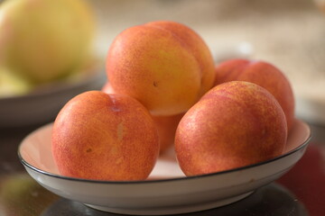 Fresh peaches placed on a plate, still life close-up