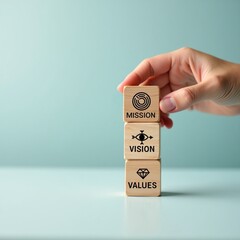 Business strategy concept with hand stacking wooden blocks showing mission, vision, and values for corporate culture.