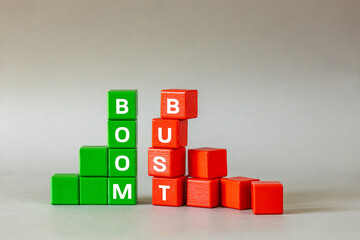Boom and bust chart. Conceptual words, Business idea, Financial market, stock market trading, market speculation, profit and loss, Bull and bear market  symbol on wooden blocks, gray background,