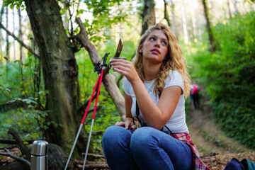 Woman hiking forest trail enjoying hot drink break