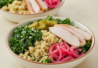 Salad bowls featuring turkey breast slices kale quinoa and pickled onions
