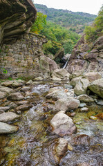 Mountain stream with rocks and small waterfall in alpine gorge, Valle d&rsquo;Aosta, Italy