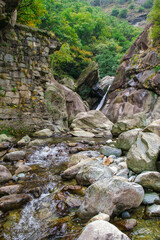 Mountain stream with rocks and small waterfall in alpine gorge, Valle d&rsquo;Aosta, Italy