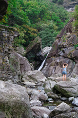 Woman admiring waterfall in alpine gorge, Valle d&rsquo;Aosta, Italy.