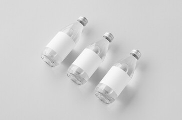 Small water bottle mockup with blank label, clear glass