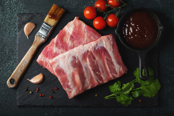 Raw meat. Raw pork ribs from the back with meat on a black background. background image