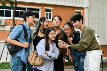 A group of diverse university students gather around a smartphone, smiling and sharing excitement, symbolizing digital connection, inclusion, and friendship in modern campus life