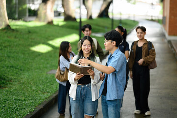 Two university students laugh and chat together on campus, enjoying a moment of friendship and joy surrounded by their classmates in a lively, relaxed atmosphere