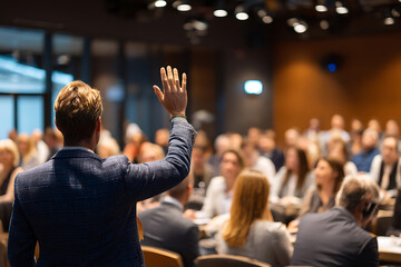 Engaged Participant in Plaid Blazer Raising Hand During a Conference Q and A Session