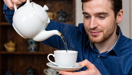 Man Pouring Tea From Teapot Into Teacup