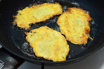 Appetizing potato pancakes are fried in a pan.  Top view. High quality photo