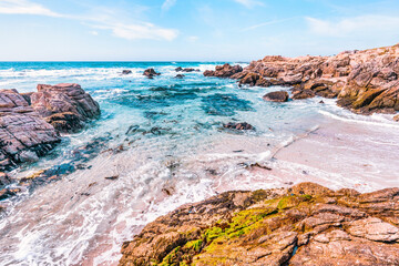 Secluded sandy beach along 17 Mile Drive in Monterey, California. Golden sand, rocky cliffs, and turquoise Pacific waters create a peaceful coastal escape on this famous scenic route