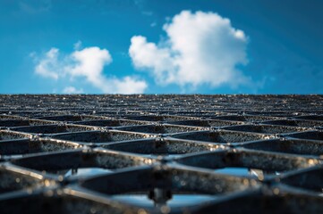 A bold metallic lattice framed by a vivid azure sky.