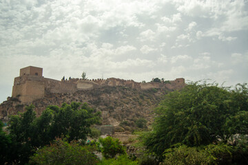 Obraz premium Historic castle on a hill under cloudy sky