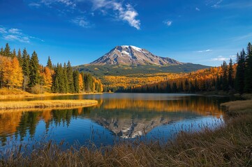 Colorful fall scene with a tranquil lake and a grand mountain towering behind it.