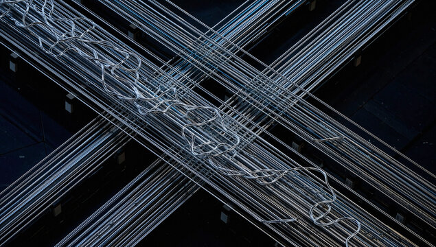 Intertwined Metal Pipes and Parallel Rods on Dark Background