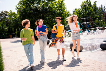 Obraz premium Group of joyous young individuals exploring a park, embracing friendship outdoors and having a lively stroll under bright sunlight