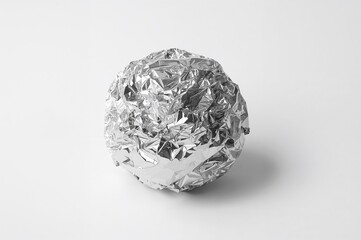 Ball of aluminum foil on a plain white surface