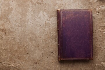 Vintage page with a purple book cover on textured aged paper, perfect for retro backgrounds and designs.