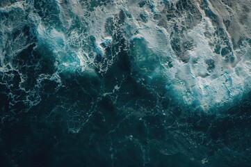 Fototapeta premium Overhead view showcasing the striking contrast of deep blue water and vivid white foam, forming a lively and intense ocean scene.