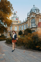 Obraz premium Young woman in leather jacket and skirt enjoying travel near medieval castle.