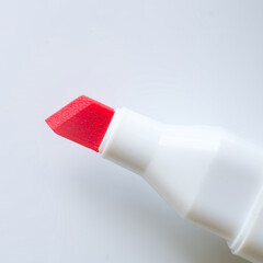Red chisel tip marker on white background, close up of art supply for drawing, writing and...