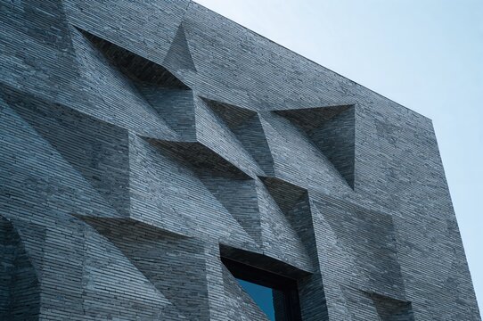 Geometric facade design with gray brick exterior and modern architectural features