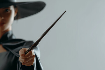 Magic wand in the hand of woman dressed in witch clothes.	 