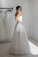 Stylish bride wearing elegant strapless wedding dress posing gracefully