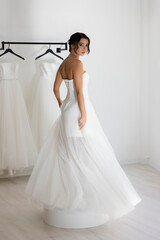 Beautiful woman wearing strapless wedding dress with corset back indoors